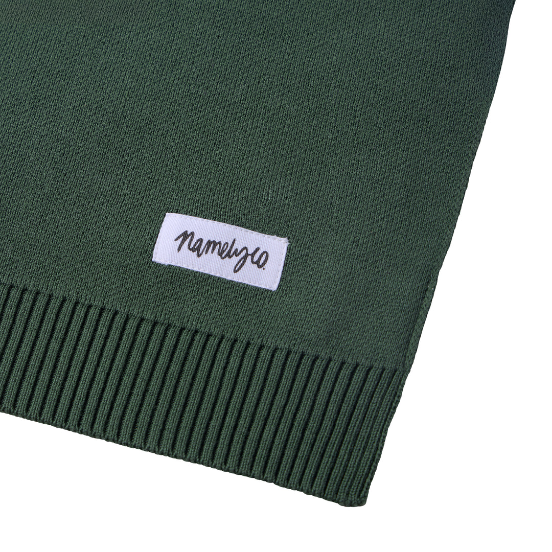 Green blanket with a white Namelyco label.