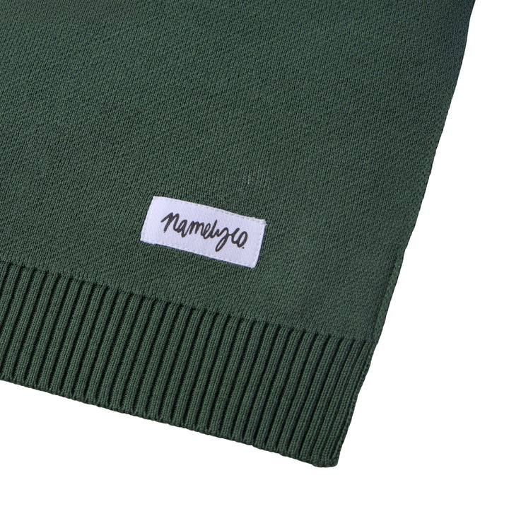 Green blanket with a white Namelyco label.